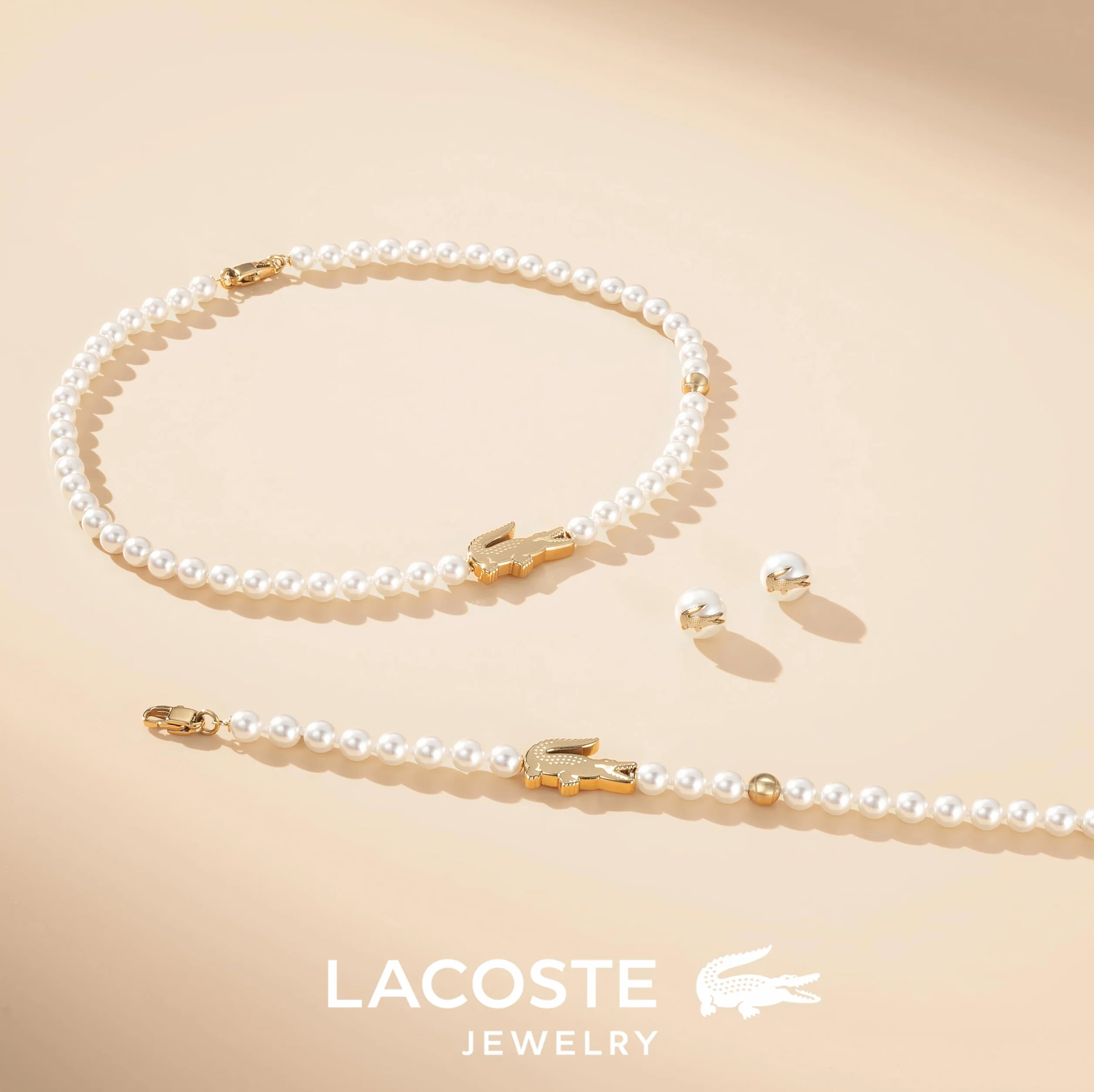 Lacoste MATCHPOINT Collection Bransoletka na naszyjnik ze sztucznymi perełkami z różnymi urokami w kolorze żółtego złota i kolczykami ze sztucznych pereł z żółtym złotem krokodylem